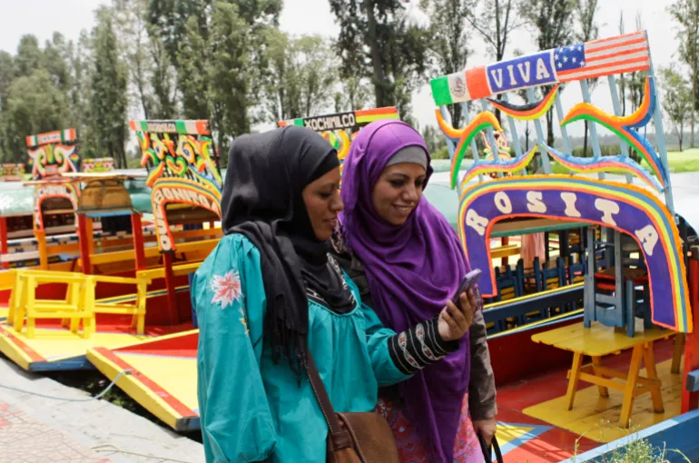 Muslim women walk past trajineras (boats) at the canals of Xochimilco as they celebrate Eid in Mexico City [File: Henry Romero/Reuters]
