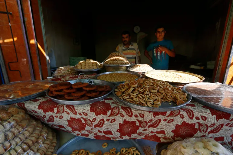 Vendors sell traditional sweets before Eid al-Adha in the Sheikh Maksoud area of Aleppo, Syria [File: Hosam Katan/Reuters]

