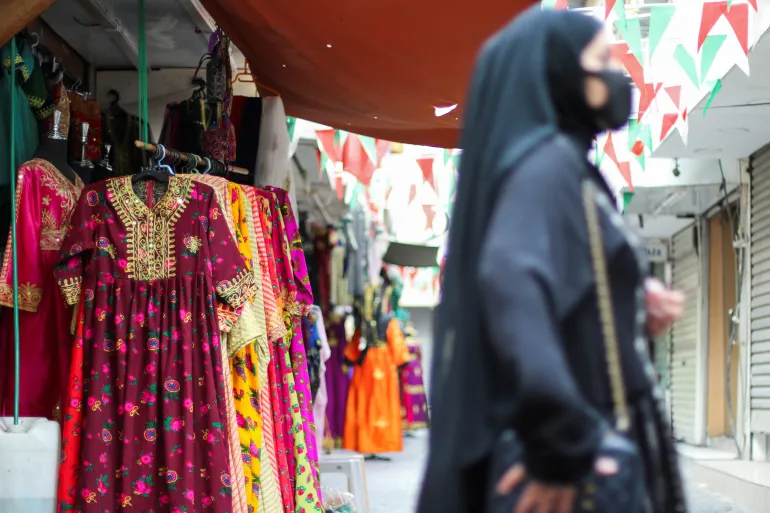 A Bahraini woman is seen shopping for a traditional jalabia before Eid at a souq in Manama, Bahrain [File: Hamad I Mohammed/Reuters]
