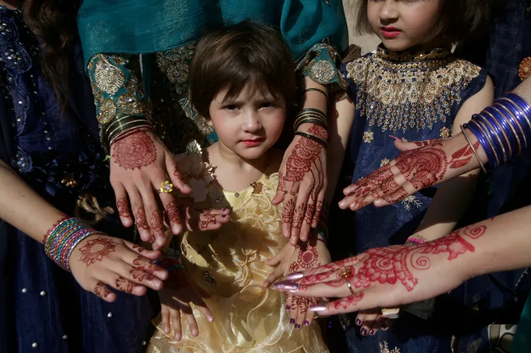 Muslim girls display their hands painted with traditional henna for Eid, in Peshawar, Pakistan [File: Muhammad Sajjad/AP Photo]
