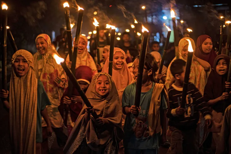 Muslim girls carry torches as they parade to celebrate Eid in Polewali Mandar, West Sulawesi, Indonesia [File: Yusuf Wahil/AP Photo]
