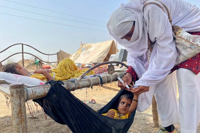 A polio worker marking a child’s finger during the first polio campaign after the floods. © WHO/Pakistan