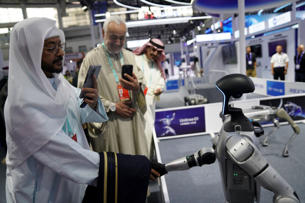 A guest shakes hands with a humanoid robot at the seventh China-Arab States Expo in Yinchuan, Ningxia Hui autonomous region, on Aug 28. ZHAO YUSI/XINHUA

