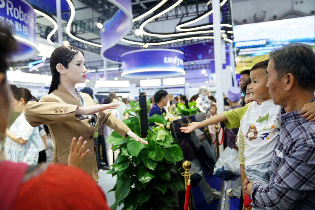 Visitors interact with an intelligent robot at the expo on Aug 29. ZHAO YUSI/XINHUA
