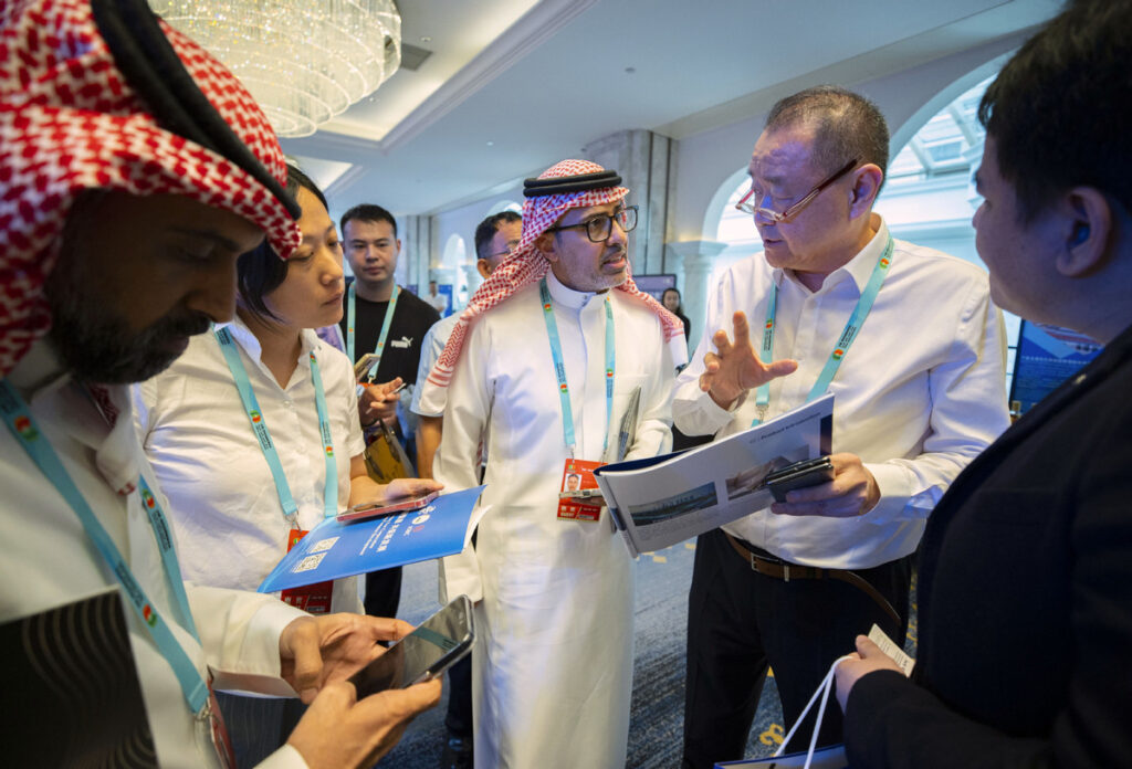 Guests hold business negotiations with the representatives of an enterprise at the expo on Aug 28. YANG ZHISEN/XINHUA
