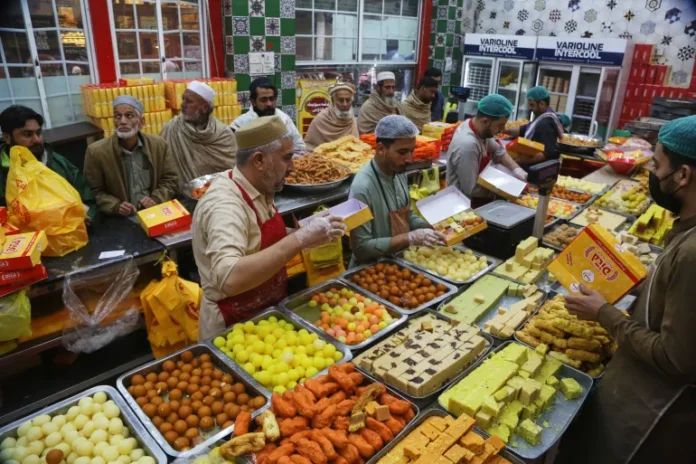 People buy traditional sweets at a shop in preparation for upcoming Eid al-Fitr celebrations, in Peshawar, Pakistan, on March 18, 2026 [Muhammad Sajjad/AP Photo]